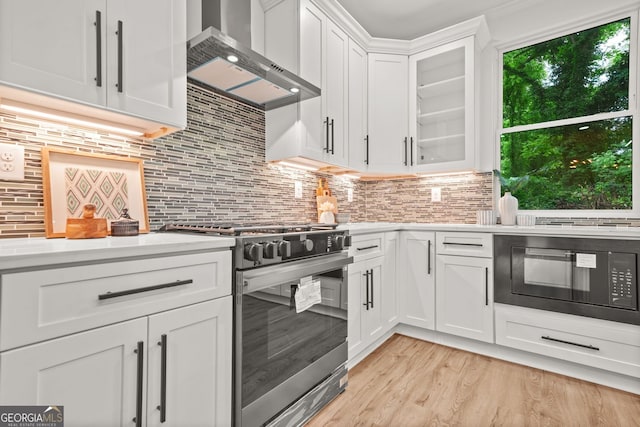 2926 5th St SW, Atlanta, GA 30315 - kitchen with stainless steel gas range oven, wall chimney range hood, black microwave, and light countertops