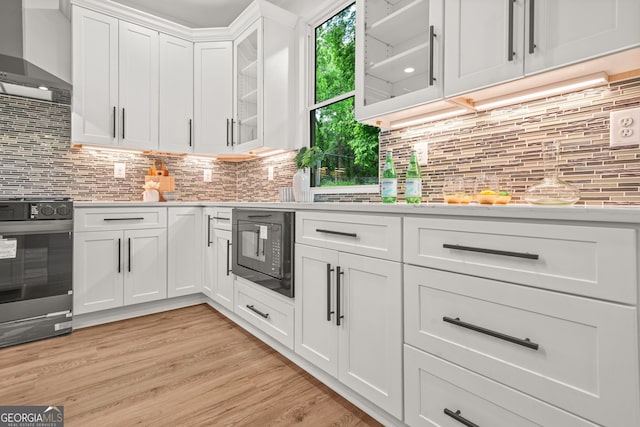 2926 5th St SW, Atlanta, GA 30315 - kitchen with stainless steel stove, wall chimney range hood, black microwave, light countertops, and white cabinets