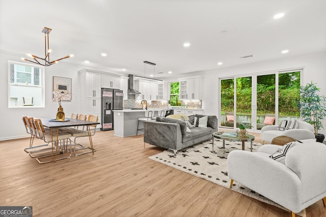 2926 5th St SW, Atlanta, GA 30315 - living room featuring light wood finished floors, healthy amount of natural light, a chandelier, recessed lighting, and baseboards