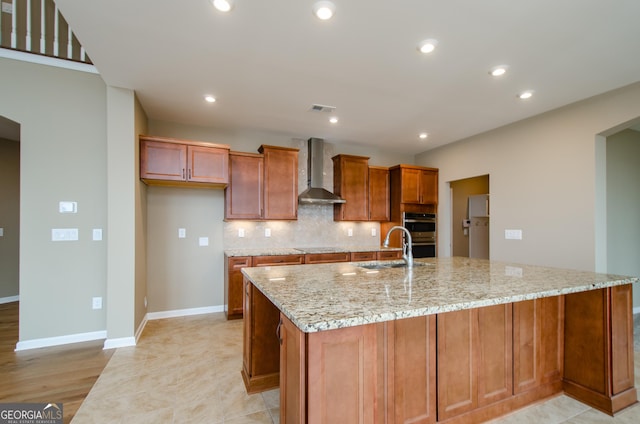 8555 Scenic Ridge Way, Ball Ground, GA 30107 - kitchen featuring wall chimney exhaust hood, a sink, a spacious island, brown cabinetry, and light stone countertops