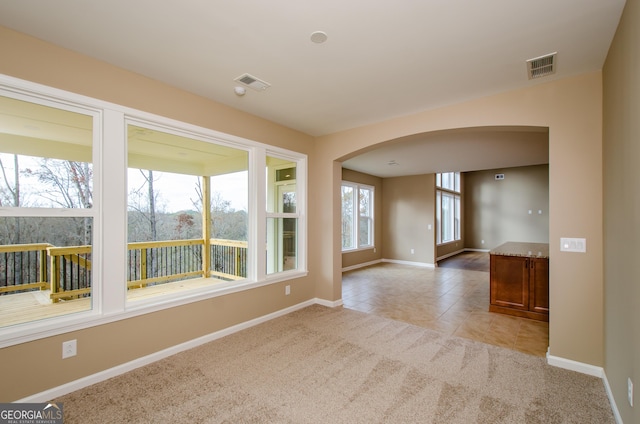 8555 Scenic Ridge Way, Ball Ground, GA 30107 - spare room with arched walkways, light carpet, and light tile patterned floors