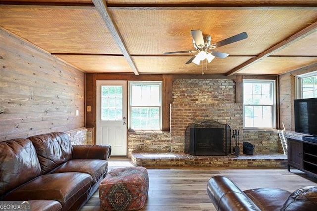 184 Rambo Pl SW, Marietta, GA 30064 - living area with wood-type flooring, wooden walls, a ceiling fan, a brick fireplace, and wooden ceiling with exposed beams