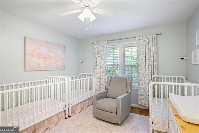 184 Rambo Pl SW, Marietta, GA 30064 - bedroom featuring wood finished floors, a crib, ceiling fan, and baseboards