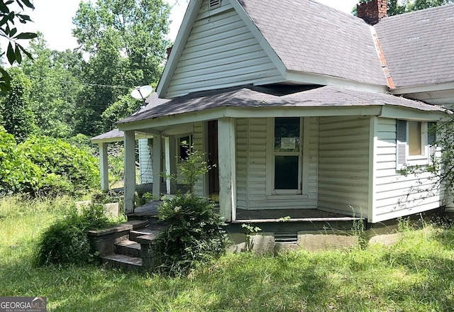 5 Lexington Rd, Carlton, GA 30627 - rear view of property with covered porch, a shingled roof, and a chimney