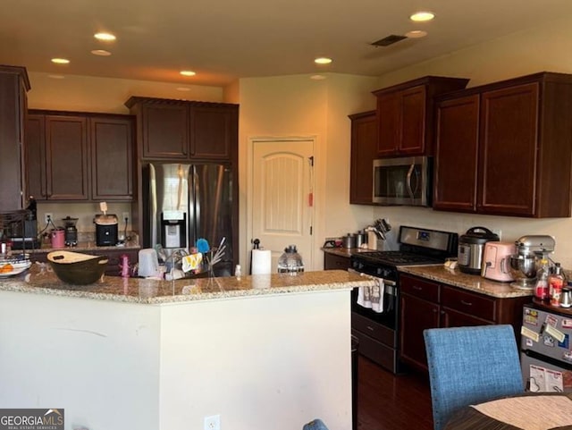 7613 Mockernut Way, Midland, GA 31820 - kitchen featuring appliances with stainless steel finishes, light stone countertops, dark brown cabinets, and recessed lighting
