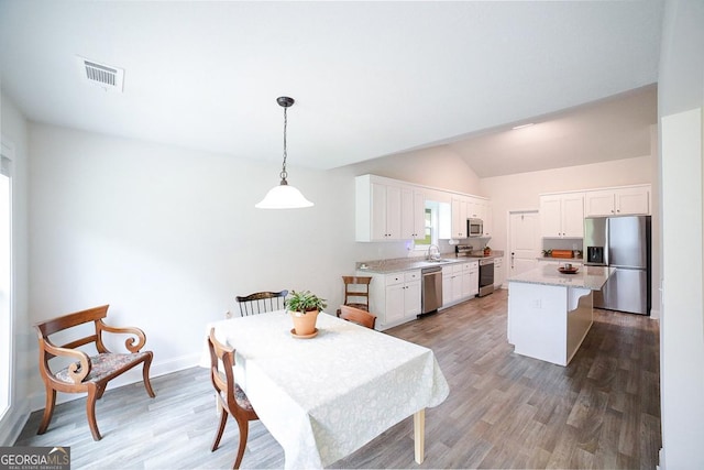 170 Kinsley Way, Statham, GA 30666 - dining space with light wood finished floors, vaulted ceiling, and plenty of natural light