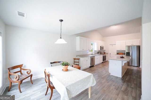 170 Kinsley Way, Statham, GA 30666 - dining area featuring light wood-style flooring, lofted ceiling, and plenty of natural light