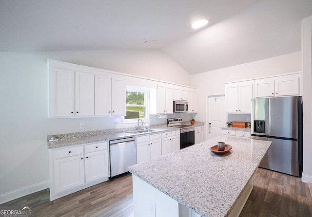 170 Kinsley Way, Statham, GA 30666 - kitchen with appliances with stainless steel finishes, a center island, white cabinetry, light stone countertops, and high vaulted ceiling