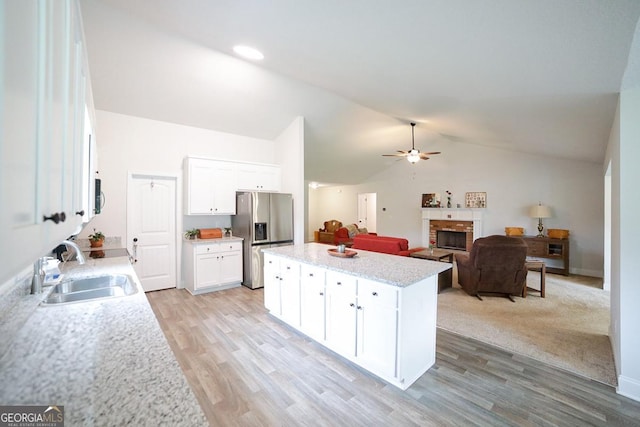 170 Kinsley Way, Statham, GA 30666 - kitchen with stainless steel refrigerator with ice dispenser, a center island, a fireplace, white cabinetry, and lofted ceiling