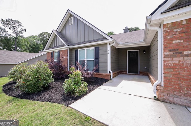 170 Kinsley Way, Statham, GA 30666 - view of exterior entry with board and batten siding, brick siding, and roof with shingles