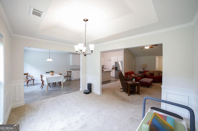 170 Kinsley Way, Statham, GA 30666 - dining space featuring light colored carpet, a raised ceiling, a decorative wall, a chandelier, and wainscoting