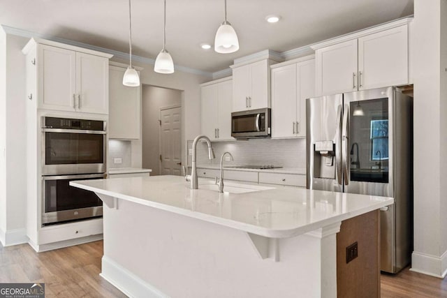724 Broken Arrow, Waleska, GA 30183 - kitchen with stainless steel appliances, light wood-type flooring, tasteful backsplash, a kitchen island with sink, and crown molding