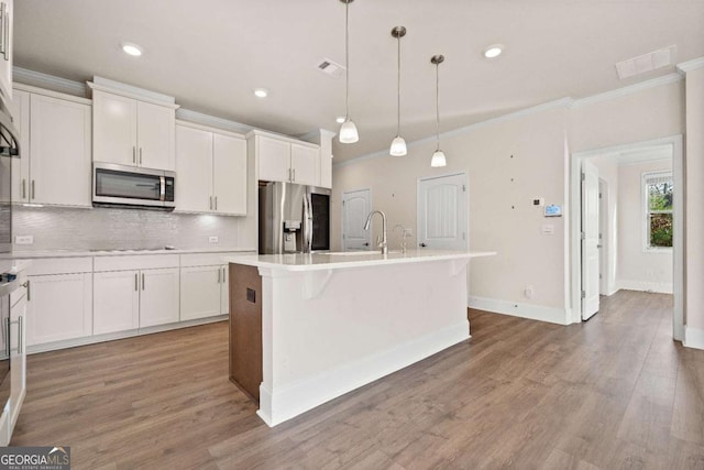 724 Broken Arrow, Waleska, GA 30183 - kitchen featuring appliances with stainless steel finishes, ornamental molding, backsplash, a center island with sink, and white cabinetry