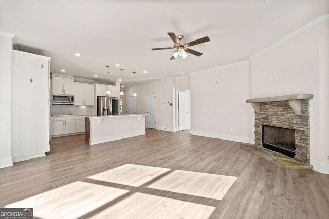 724 Broken Arrow, Waleska, GA 30183 - unfurnished living room featuring a ceiling fan, light wood finished floors, a fireplace, baseboards, and crown molding
