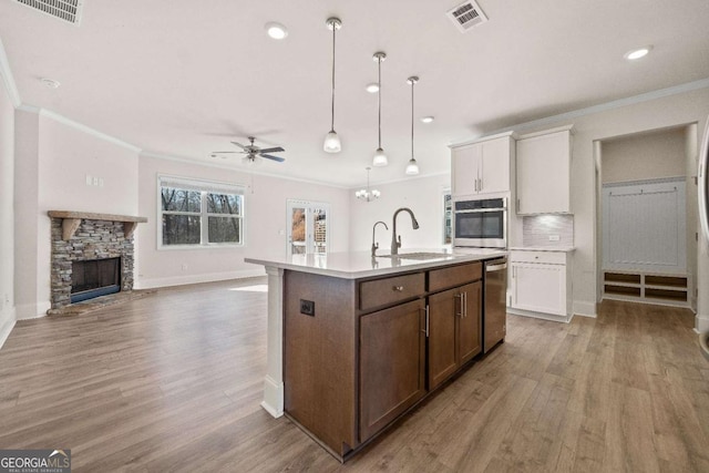 724 Broken Arrow, Waleska, GA 30183 - kitchen with stainless steel appliances, a sink, ceiling fan, ornamental molding, and light wood finished floors
