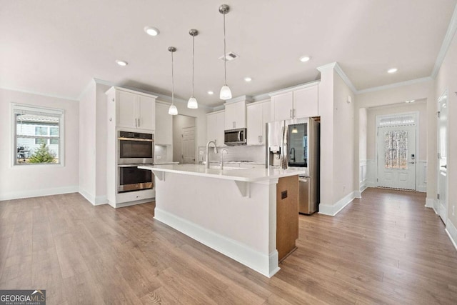 724 Broken Arrow, Waleska, GA 30183 - kitchen featuring appliances with stainless steel finishes, ornamental molding, light countertops, a kitchen breakfast bar, and light wood-type flooring