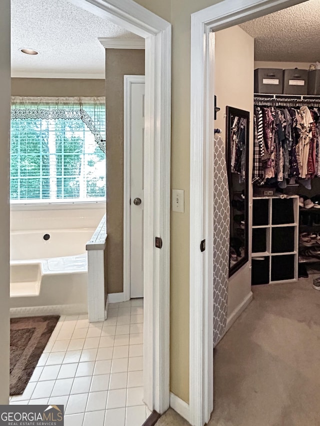 21 Picketts Rdg, Acworth, GA 30101 - bathroom featuring a textured ceiling, a garden tub, a walk in closet, crown molding, and tile patterned flooring
