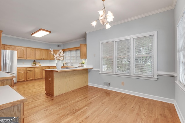 1285 Rivershyre Pkwy, Lawrenceville, GA 30043 - kitchen featuring freestanding refrigerator, a peninsula, light countertops, a chandelier, and ornamental molding