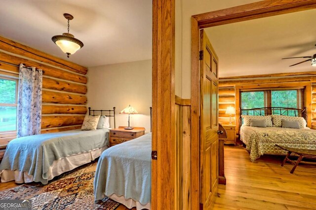 6487 W Old Highway 64 W, Warne, NC 28909 - bedroom featuring rustic walls, light wood finished floors, and multiple windows