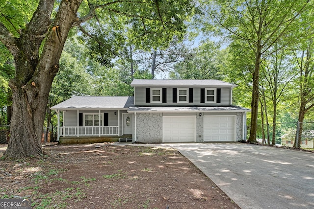 2894 Cushing Ct, Jonesboro, GA 30236 - tri-level home featuring a porch, driveway, an attached garage, stone siding, and roof with shingles