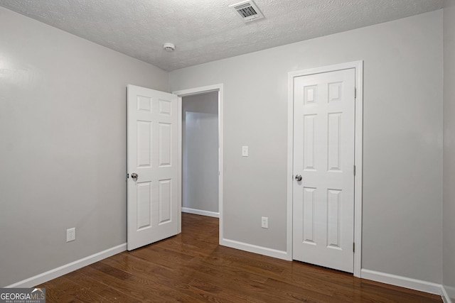 2894 Cushing Ct, Jonesboro, GA 30236 - unfurnished bedroom with dark wood finished floors, baseboards, and a textured ceiling