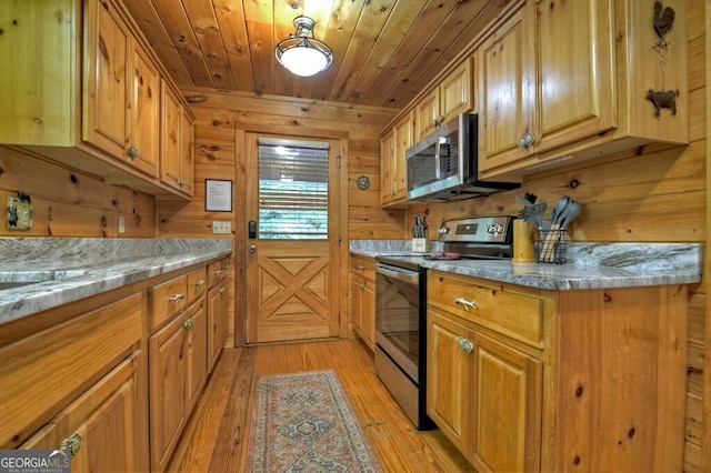 294 Oakwood Trl, Mineral Bluff, GA 30559 - kitchen featuring appliances with stainless steel finishes, wood walls, light wood-type flooring, wood ceiling, and brown cabinetry