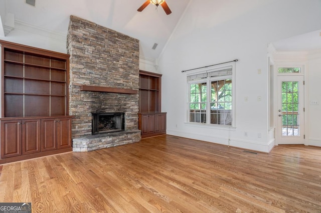 5620 Barnett Shoals Rd, Athens, GA 30605 - unfurnished living room featuring light wood finished floors, a ceiling fan, a stone fireplace, high vaulted ceiling, and crown molding