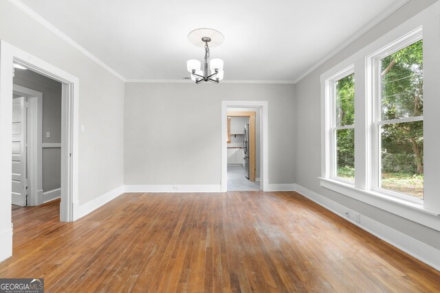 107 S Mulberry St, Statesboro, GA 30458 - empty room with a chandelier, hardwood / wood-style floors, and crown molding