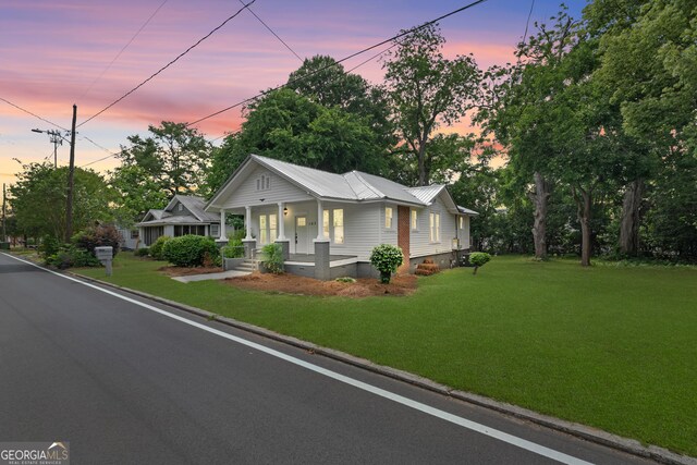 107 S Mulberry St, Statesboro, GA 30458 - view of front of property with covered porch, crawl space, a lawn, and a metal roof