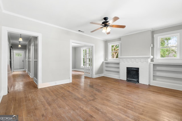 107 S Mulberry St, Statesboro, GA 30458 - unfurnished living room featuring a ceiling fan, hardwood / wood-style flooring, crown molding, a brick fireplace, and baseboards