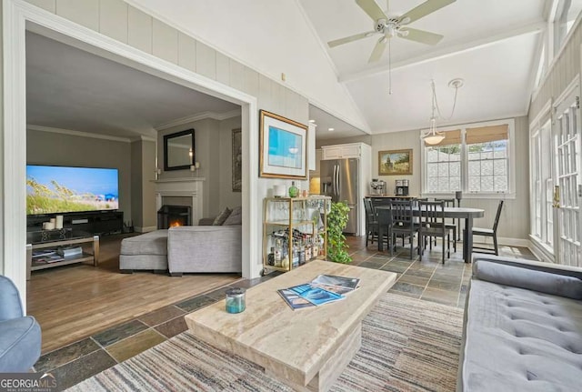 3734 Powers Ferry Rd NW, Atlanta, GA 30342 - living room featuring stone tile flooring, ceiling fan, lofted ceiling, a lit fireplace, and ornamental molding