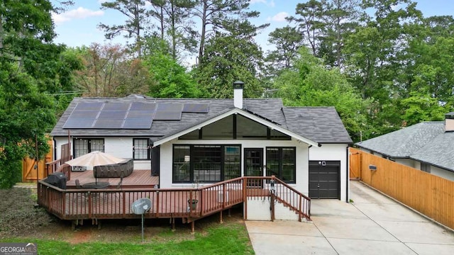 3734 Powers Ferry Rd NW, Atlanta, GA 30342 - back of house with concrete driveway, roof mounted solar panels, a garage, a deck, and a shingled roof