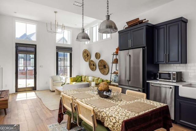 135 Mado Ln, Chattahoochee Hills, GA 30268 - dining space featuring healthy amount of natural light, light wood finished floors, and a high ceiling