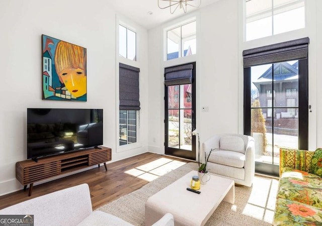 135 Mado Ln, Chattahoochee Hills, GA 30268 - living room featuring wood finished floors, a high ceiling, and a chandelier