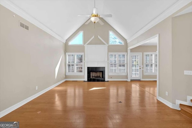 2021 Cockrell Pointe NW, Kennesaw, GA 30152 - unfurnished living room with wood finished floors, ceiling fan, a tiled fireplace, high vaulted ceiling, and baseboards