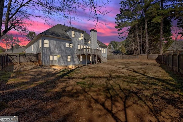 2021 Cockrell Pointe NW, Kennesaw, GA 30152 - back of house at dusk featuring a deck, a chimney, and stairs