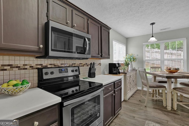 507 Hillcrest Cross Rd, Canton, GA 30115 - kitchen featuring appliances with stainless steel finishes, dark brown cabinetry, light wood-style flooring, light countertops, and decorative backsplash