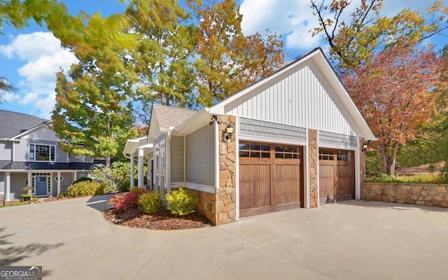 1951 Island View Dr, Hiawassee, GA 30546 - view of side of property with stone siding, driveway, board and batten siding, and an attached garage