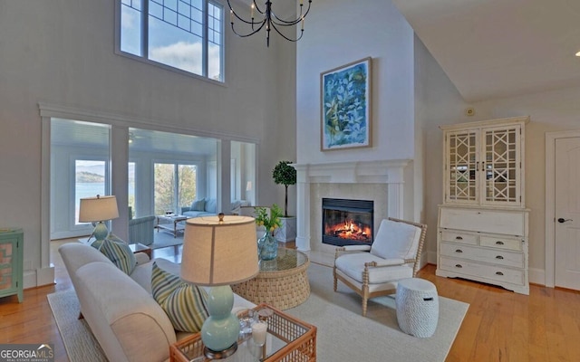 1951 Island View Dr, Hiawassee, GA 30546 - living area with a high ceiling, wood finished floors, a high end fireplace, and a chandelier