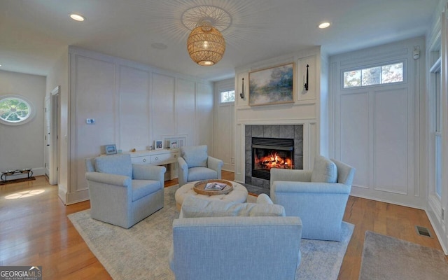 1951 Island View Dr, Hiawassee, GA 30546 - living room with a decorative wall, a tiled fireplace, plenty of natural light, wood finished floors, and recessed lighting