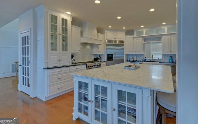 1951 Island View Dr, Hiawassee, GA 30546 - kitchen featuring stainless steel built in fridge, custom exhaust hood, decorative backsplash, light wood-style floors, and recessed lighting
