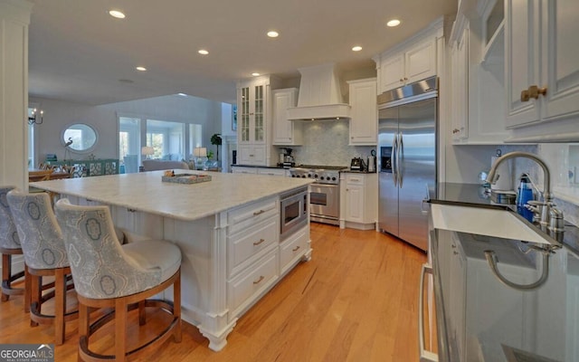 1951 Island View Dr, Hiawassee, GA 30546 - kitchen with built in appliances, custom exhaust hood, a sink, white cabinets, and recessed lighting