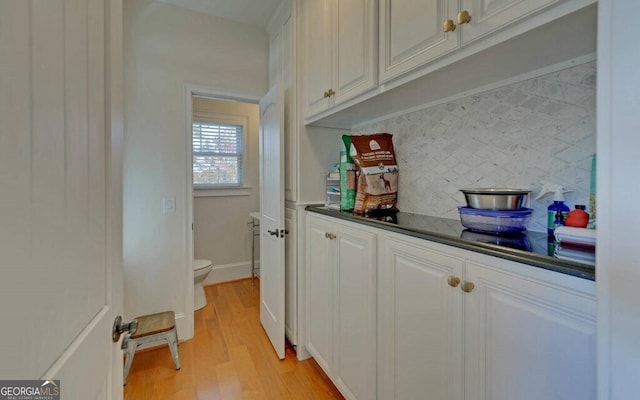 1951 Island View Dr, Hiawassee, GA 30546 - kitchen with tasteful backsplash, light wood-style flooring, dark countertops, and white cabinets