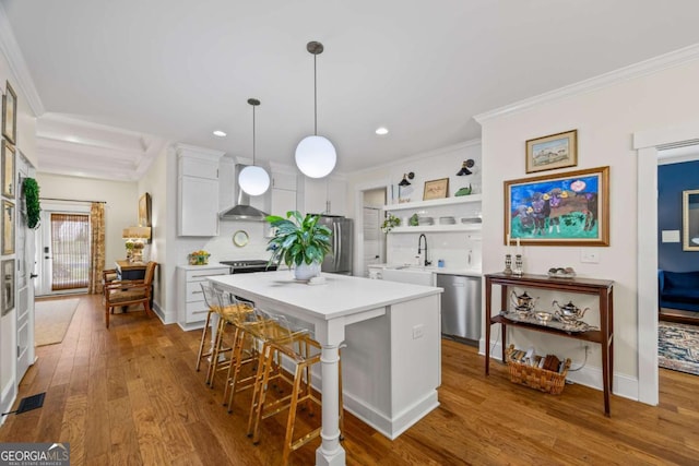 555 Red Bluff Dr, Athens, GA 30607 - kitchen with appliances with stainless steel finishes, ornamental molding, wall chimney range hood, white cabinets, and dark wood-style floors