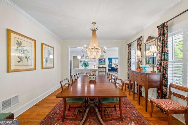 555 Red Bluff Dr, Athens, GA 30607 - dining room featuring wood finished floors, a chandelier, and crown molding