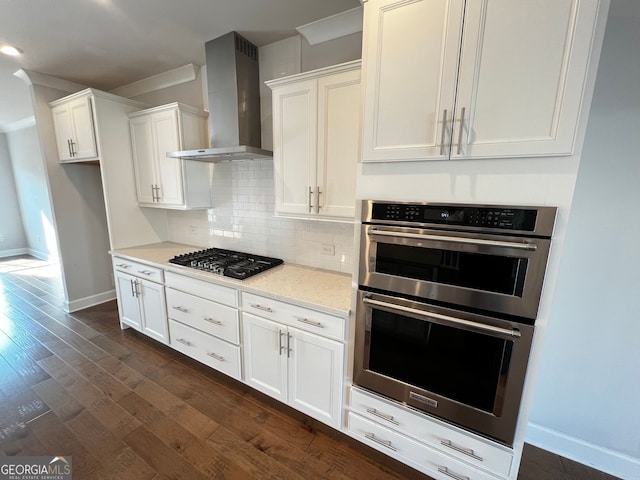 996 Layton Dr, Buford, GA 30518 - kitchen with wall chimney range hood, appliances with stainless steel finishes, tasteful backsplash, white cabinets, and light stone countertops