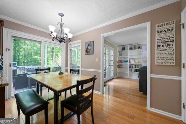 1769 Milford Creek Cts SW, Marietta, GA 30008 - dining space featuring a chandelier, light wood-style flooring, crown molding, and a textured ceiling