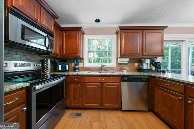 1769 Milford Creek Cts SW, Marietta, GA 30008 - kitchen featuring stainless steel appliances, ornamental molding, light stone counters, light wood-style flooring, and decorative backsplash