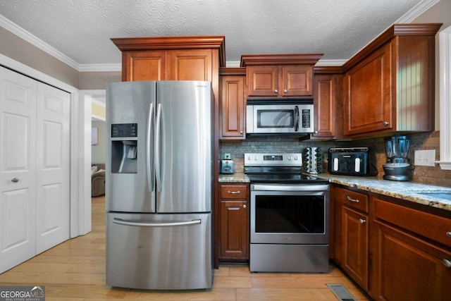 1769 Milford Creek Cts SW, Marietta, GA 30008 - kitchen featuring stainless steel appliances, backsplash, light wood finished floors, crown molding, and a textured ceiling