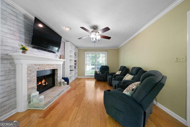 1769 Milford Creek Cts SW, Marietta, GA 30008 - living room featuring wood finished floors, a textured ceiling, a ceiling fan, a stone fireplace, and crown molding
